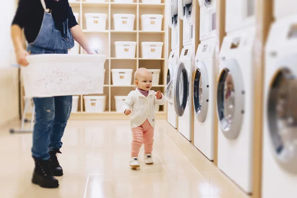Mamma och baby i tvätten ta saker och spela — Stockfoto