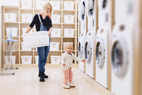 Mamma och baby i tvätten ta saker och spela — Stockfoto