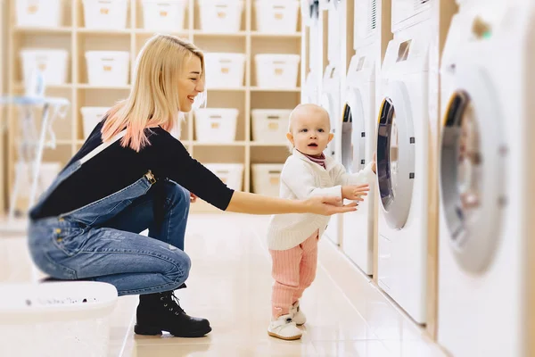 Mamma och baby i tvätten ta saker och spela — Stockfoto