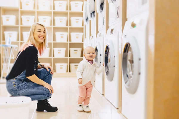 Mamma och baby i tvätten ta saker och spela — Stockfoto