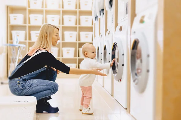 Mamma och baby i tvätten ta saker och spela — Stockfoto