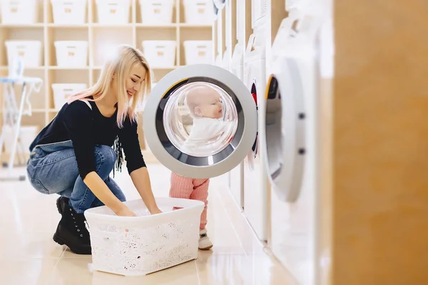 Mamma och baby i tvätten ta saker och spela — Stockfoto