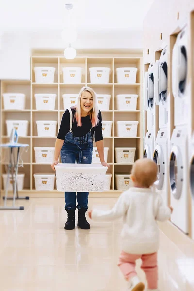 Mamma och baby i tvätten ta saker och spela — Stockfoto