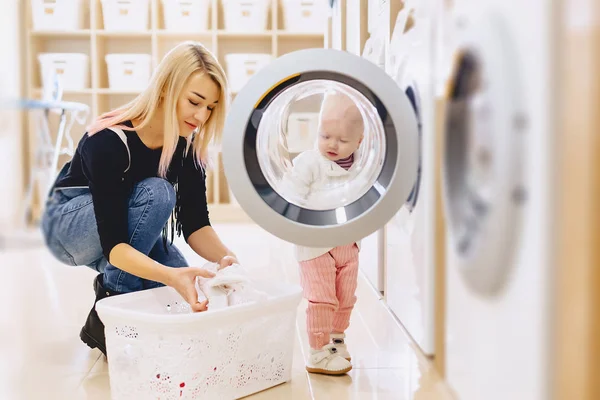 Mamma och baby i tvätten ta saker och spela — Stockfoto