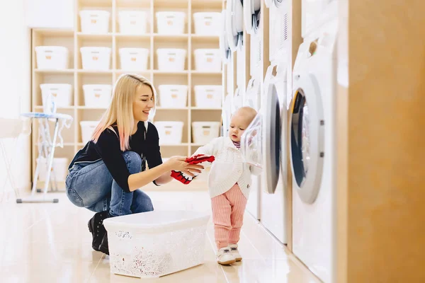 Mamma och baby i tvätten ta saker och spela — Stockfoto