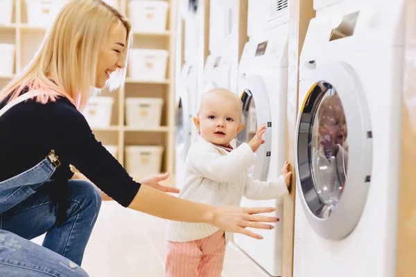 Mamma och baby i tvätten ta saker och spela — Stockfoto