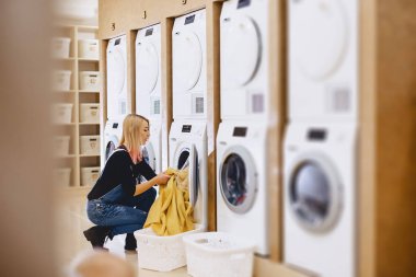 Bir kadın yük içinde çamaşır yıkama ve kuru yaprak