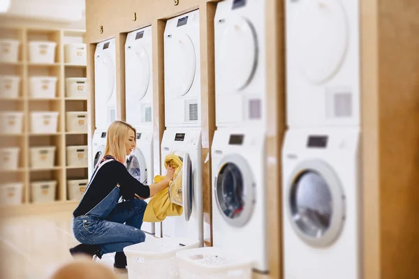 Een vrouw laden bladen in de wasruimte te wassen en drogen — Stockfoto