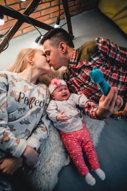 Anne, baba ve bebek yün halı ve gülümseme yalan