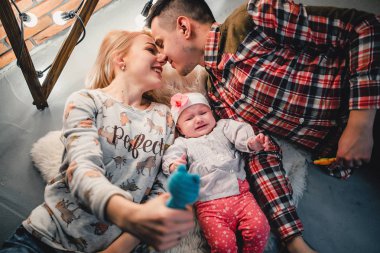 Anne, baba ve bebek yün halı ve gülümseme yalan