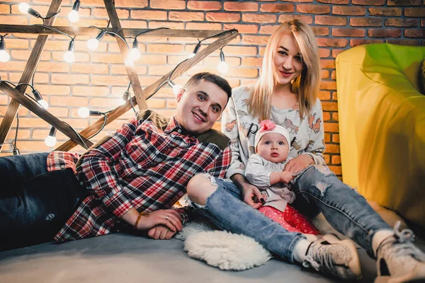 Parents with their child on the background of a star with bulbs — Stock Photo, Image