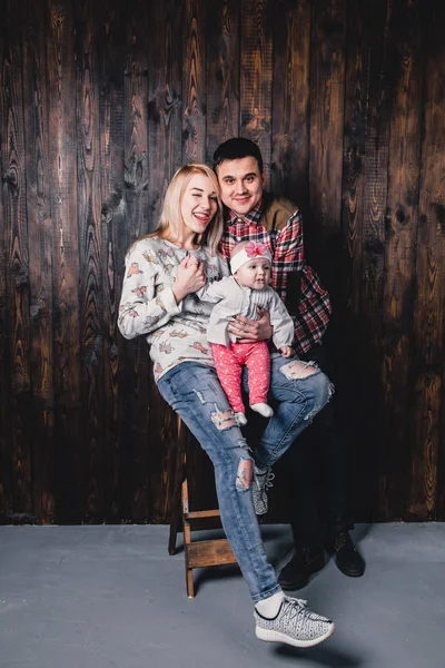 Madre y padre con su bebé en una silla de bar contra el bac — Foto de Stock