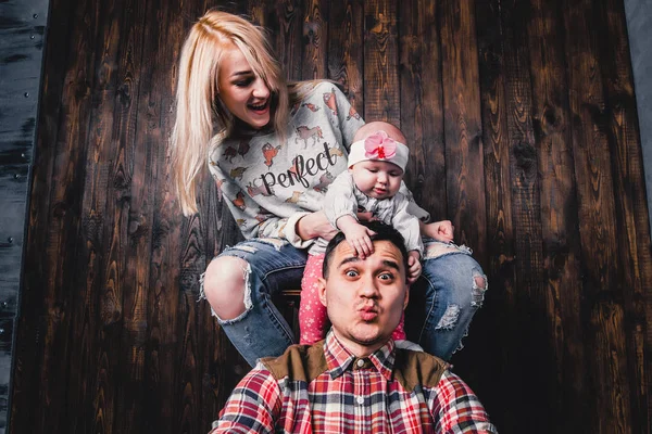 Mutter und Vater mit Baby im Barstuhl gegen den Bac — Stockfoto