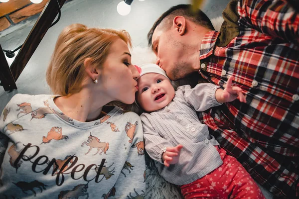 Mama, Papa und Baby liegen auf einem Wollteppich und lächeln — Stockfoto