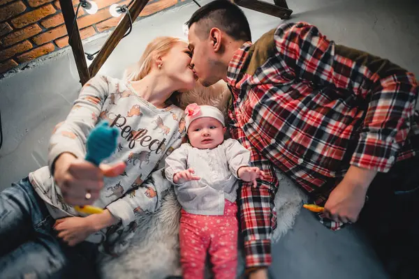 Mama, Papa und Baby liegen auf einem Wollteppich und lächeln — Stockfoto