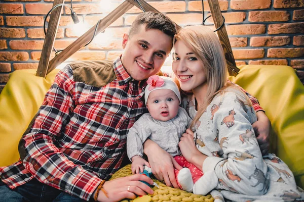 Mom, dad and baby sit on the couch and embrace — Stock Photo, Image