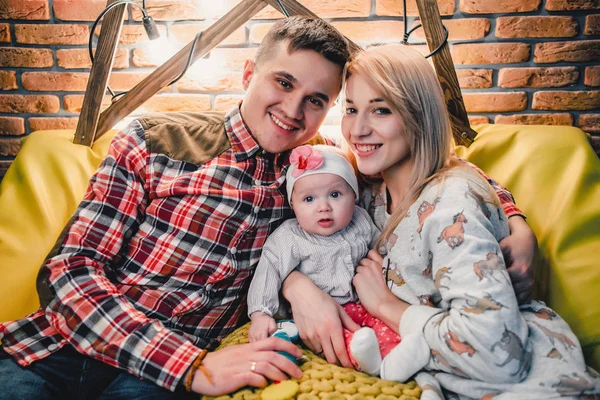 Mãe, pai e bebê sentar no sofá e abraçar — Fotografia de Stock