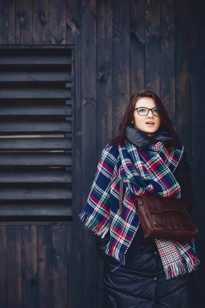 Красива дівчина в окулярах і шарф на дерев'яній стіні — стокове фото