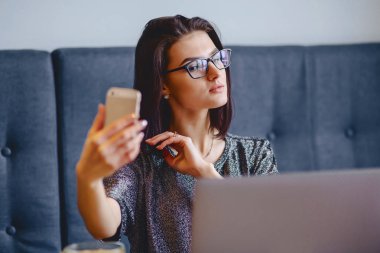 Bir çekici kız bir selfie yapıyor bir dizüstü bilgisayar için bir gözlük