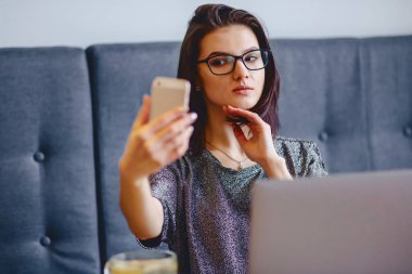 Bir çekici kız bir selfie yapıyor bir dizüstü bilgisayar için bir gözlük