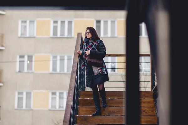 여자 겨울에 입고 안경을 착용 나무 계단 — 스톡 사진