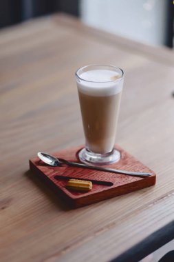 Latte ahşap bir masa üzerinde bir yüksek cam