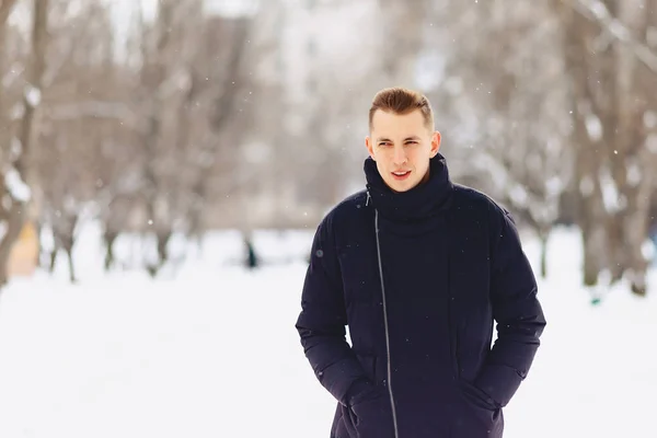 En kille med ljus kort hår i en vinterjacka utgör till kom — Stockfoto
