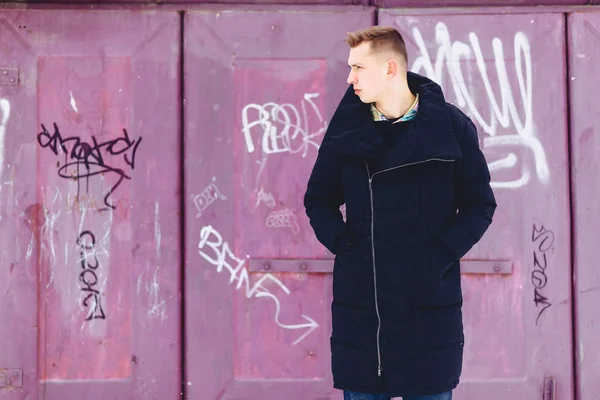 Boy in a winter jacket against the background of the wall — Stock Photo, Image