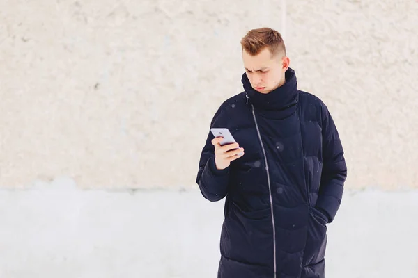 Tip în jacheta de iarnă scrie sms — Fotografie, imagine de stoc