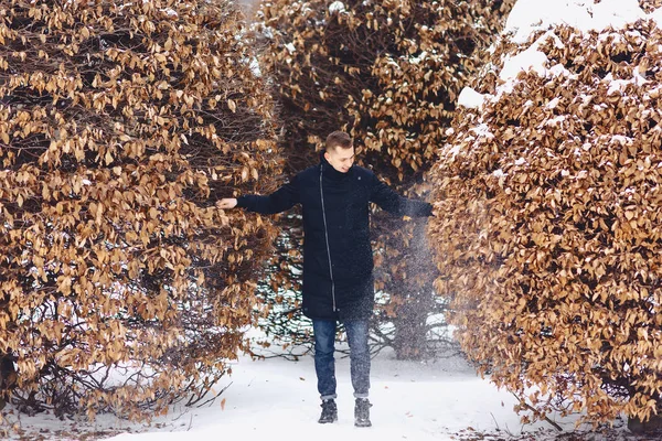 boy in a winter jacket among the winter trees