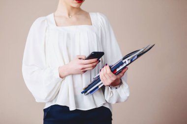 İş kadını ellerini duvara çerçevede belgelerde ile telefonu mesajlaşma