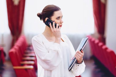 Kız belgelerle telefonla konuşuyor