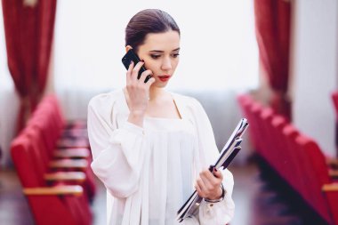 Kız belgelerle telefonla konuşuyor