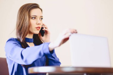 iş kadını dizüstü bilgisayarda ofis ve çalışma telefonla konuşuyor