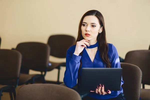 girl in auditorium works with laptop