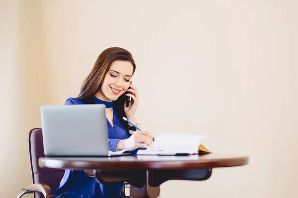 iş kadını dizüstü bilgisayarda ofis ve çalışma telefonla konuşuyor