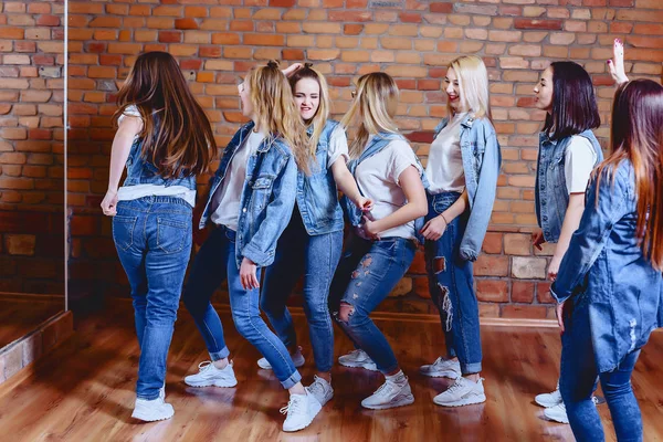 Mädchen in Jeans vor Backsteinmauer — Stockfoto