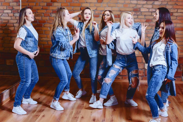 Mädchen in Jeans vor Backsteinmauer — Stockfoto