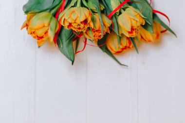 Beyaz ahşap zemin üzerinde turuncu laleler