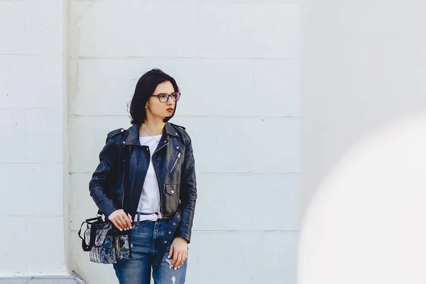 Kvinna i glasögon i skinnjacka på gatan — Stockfoto