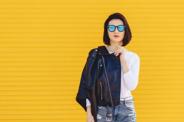 Güzel kız güneş gözlüğü parlak sarı zemin üzerine