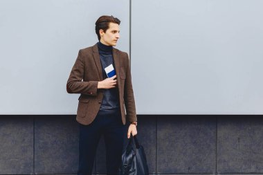 pasaport ve bilet ile ceketli şık çekici çocuk