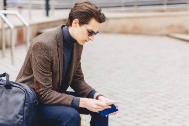 pasaport ve bilet ile ceketli şık çekici çocuk