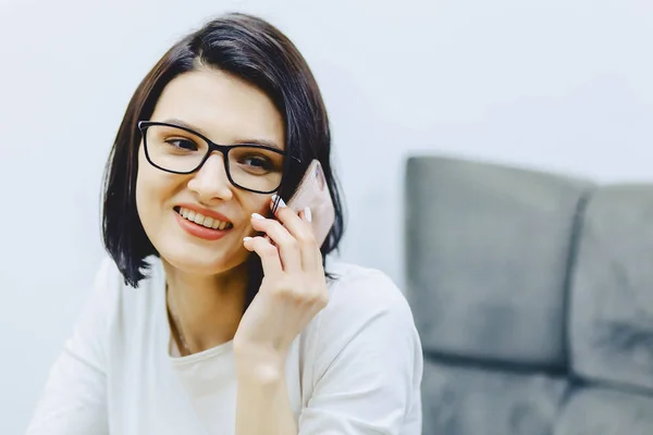 Aantrekkelijke lachende meisje spreekt telefonisch — Stockfoto