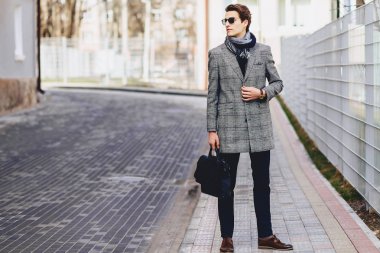 Evrak Çantası'nı Caddesi üzerinde paltoyla içinde güneş gözlüğü şık çocuk