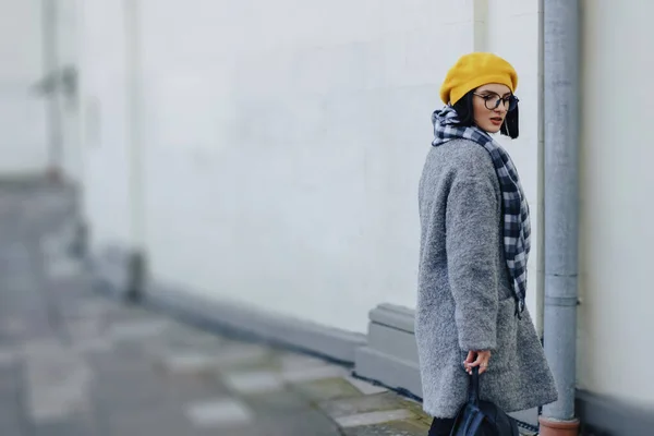 Menina atraente em óculos de casaco e amarelo Beret freestyle andando — Fotografia de Stock