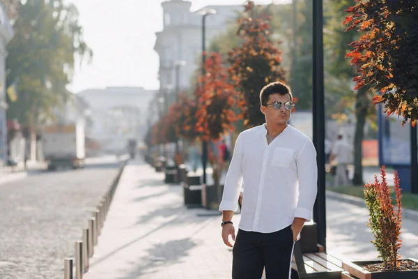 Ung snygg kille i skjorta går ner en europeisk gata på en solig dag — Stockfoto