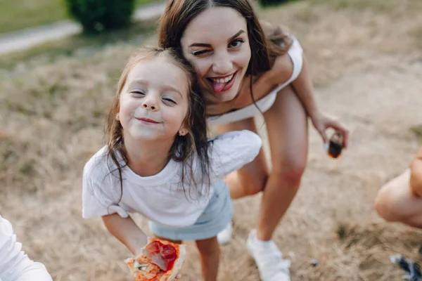 Küçük kız piknikte, pizzada, içkide, yazda ve çimlerde eğleniyor. — Stok fotoğraf