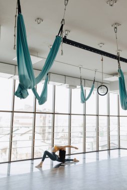panoramik pencerelerin arka planına karşı katta Yoga ile Fitness egzersizleri yapan genç çekici kız