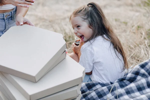 Liten flicka som har roligt på picknick, pizza, drycker, sommar och gräsmatta — Stockfoto